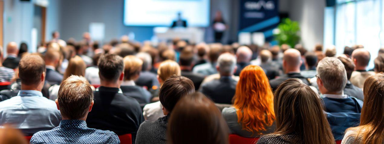 Menschen bei einer Business-Konferenz in Duesseldorf, Fokus auf Teilnehmende in moderner Tagungsumgebung – Symbolbild fuer Duesseldorf Tagungsraeume